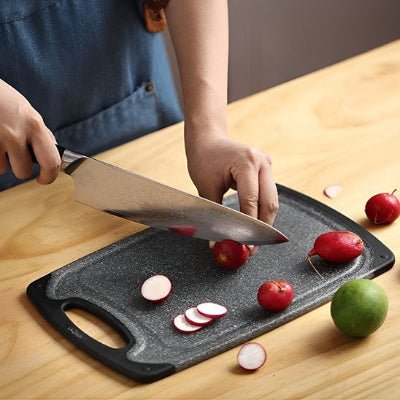 Poignée ergonomique intégrée de la planche à découper noire pour une manipulation facile.