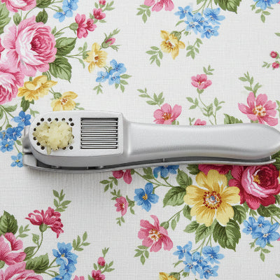 "Gros plan sur la grille en acier inoxydable du presse-ail Garlic™ facile à nettoyer sous l'eau."