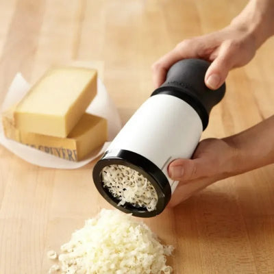 Râpage de chocolat noir en copeaux fins sur un dessert avec la râpe rotative ErgoSlice.